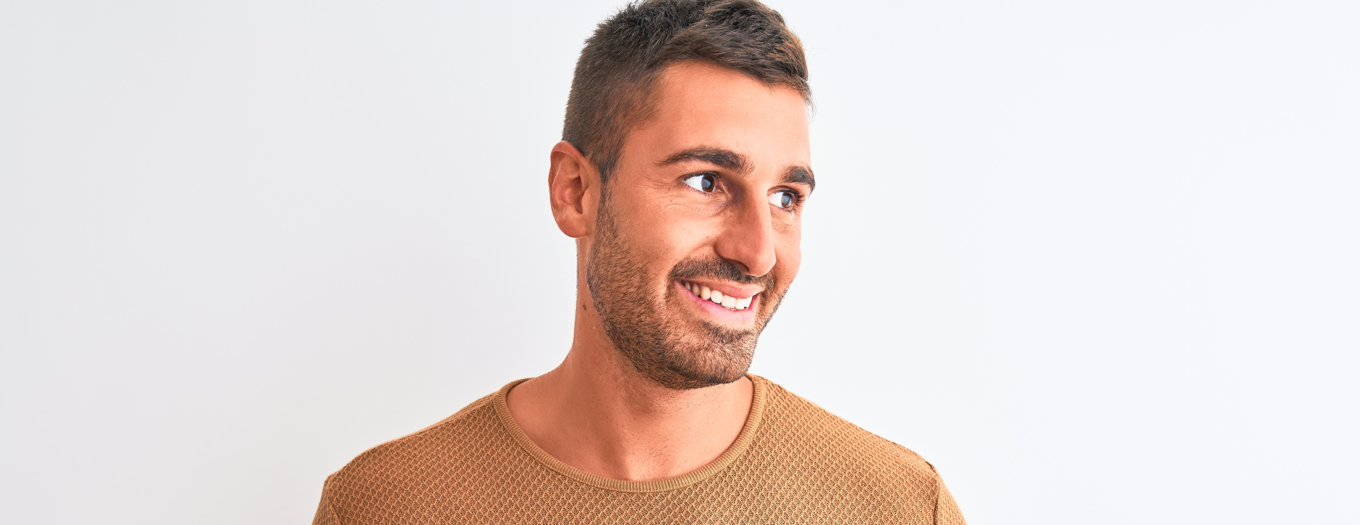 Man wearing a gold sweater against a white background