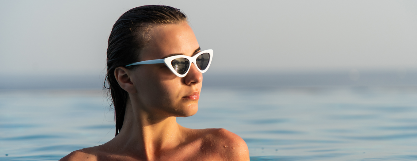Woman wearing sun glasses in a body of water