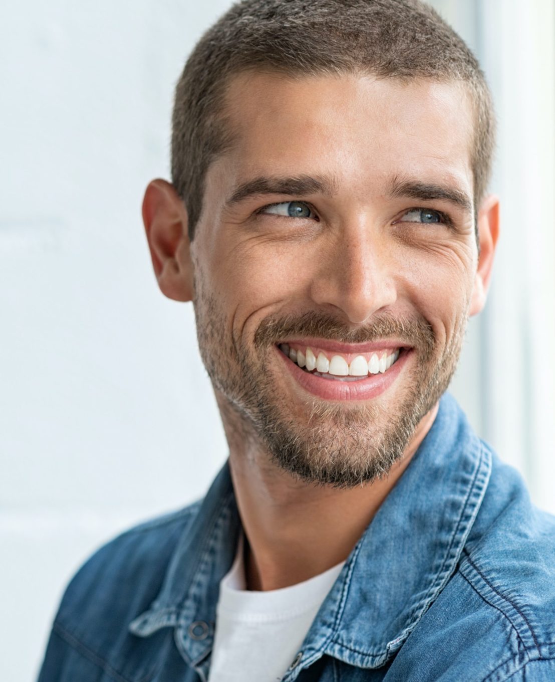 Smiling man wearing a denim shirt