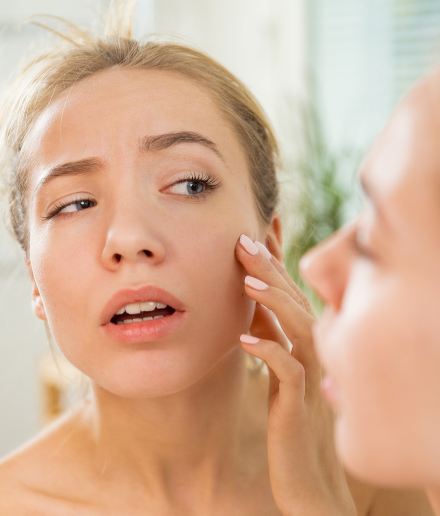 Woman inspecting her skin after LightStim LED therapy