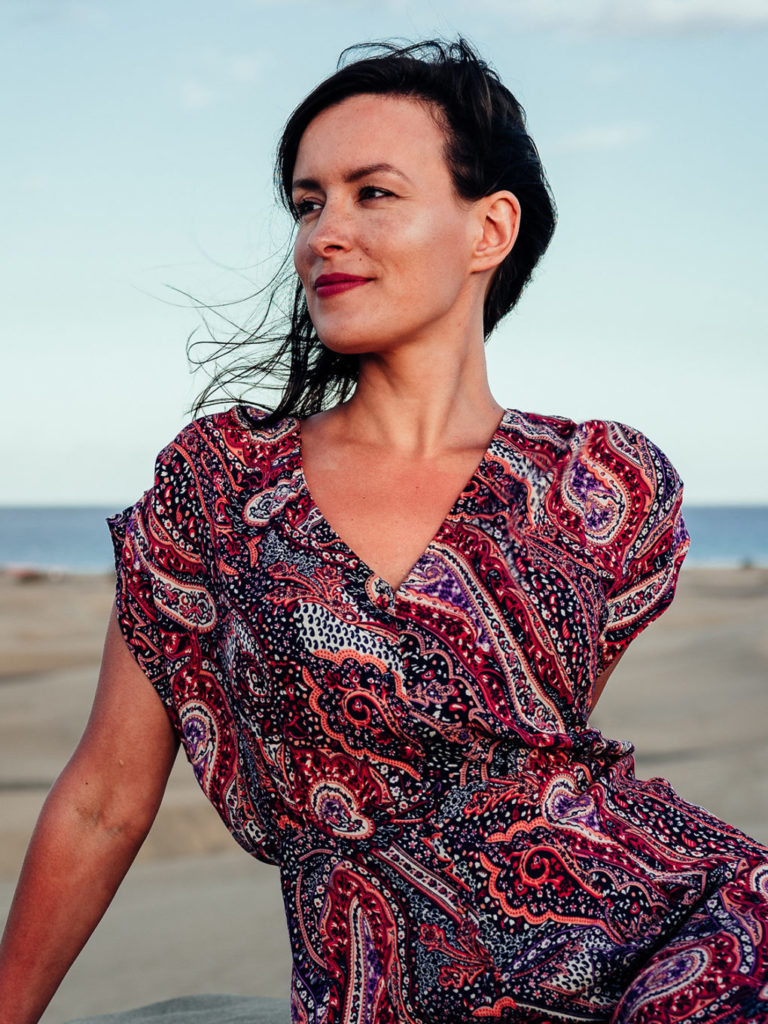 Woman in a red dress at the beach